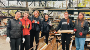 Students in athletic apparel working with construction materials